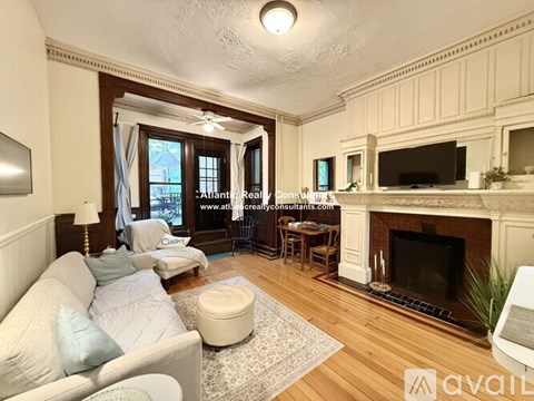 A living room with a fireplace and a television on the wall.