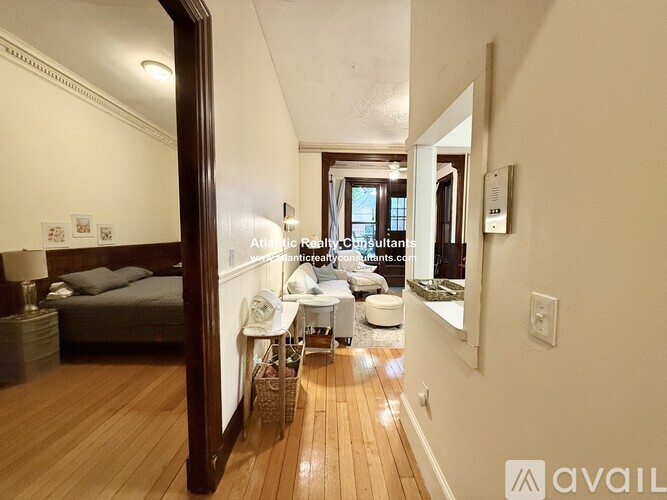 A well-lit, spacious room with a bed, a chair, and a table.