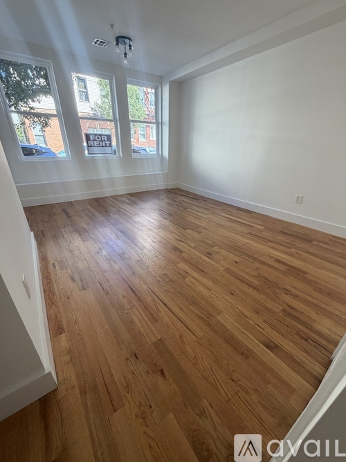 A room with wooden flooring and white walls.