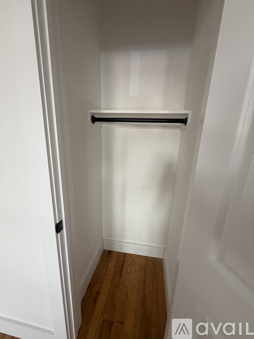 A white door with a black handle and a white wall.
