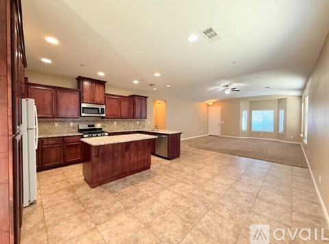 A kitchen with brown cabinets and a white refrigerator.