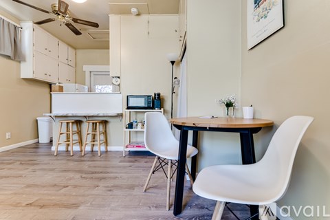 A kitchen with a table and chairs.
