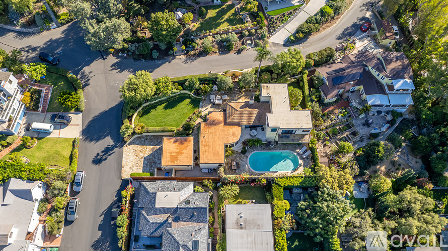 A bird's eye view of a residential area with a swimming pool.