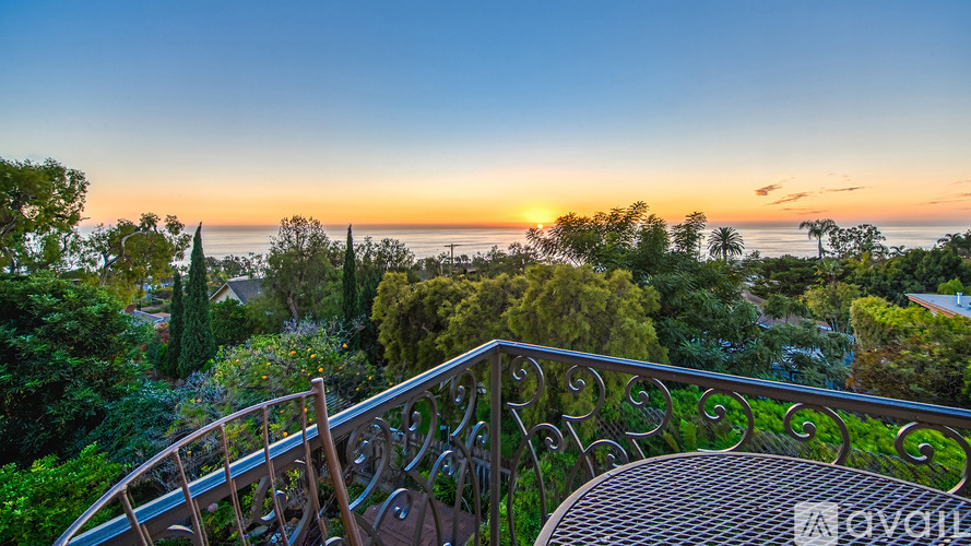 A beautiful sunset view from a balcony with a railing.