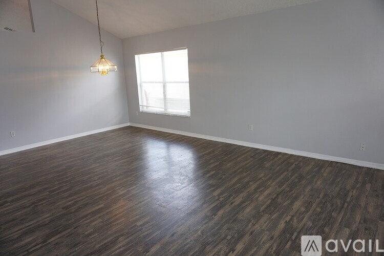 A room with wooden flooring and a hanging light fixture.