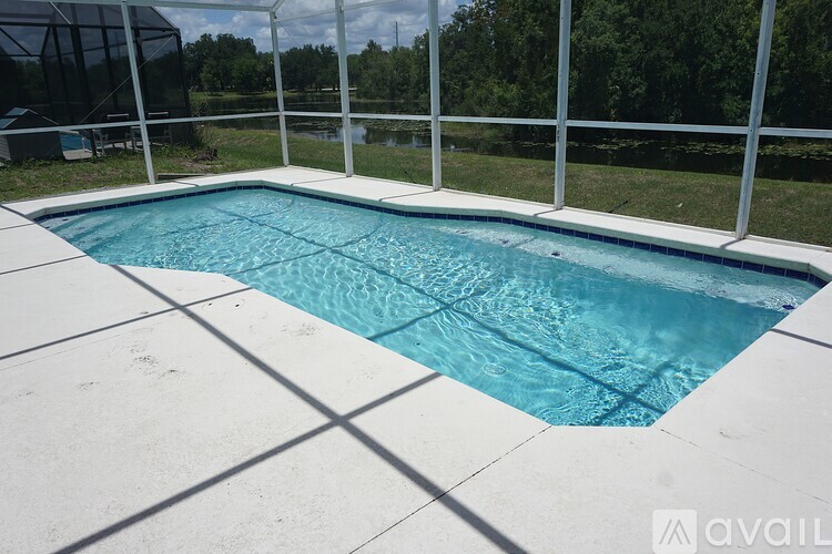 A pool surrounded by a white fence and tiled floor.