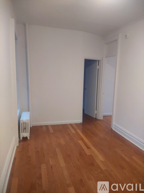 A room with wooden floors and a white radiator.