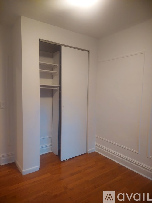 A room with a white door and shelves inside.