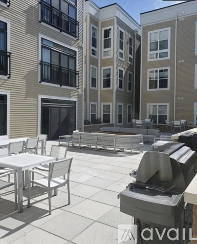 A patio with a table and chairs is in front of a building.