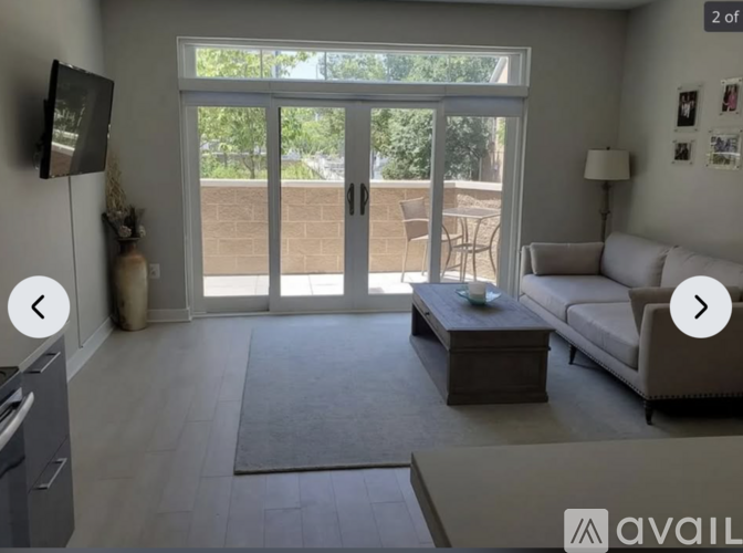 A living room with a couch, coffee table, and sliding glass doors.