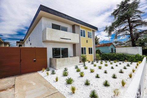 A modern house with a white and yellow exterior and a brown garage door.
