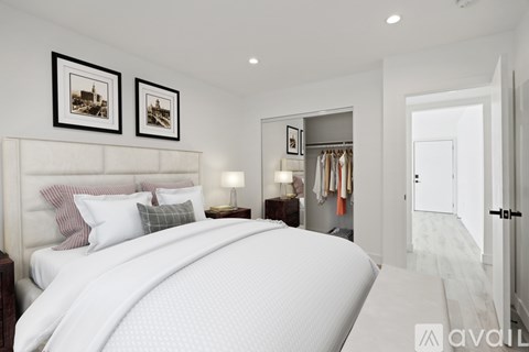 A bedroom with a large bed and two pictures on the wall.