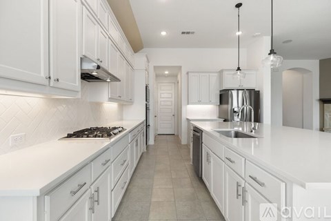 A modern kitchen with white cabinets and a tiled backsplash.