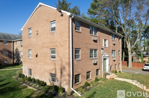 A brick building with a green lawn in front.