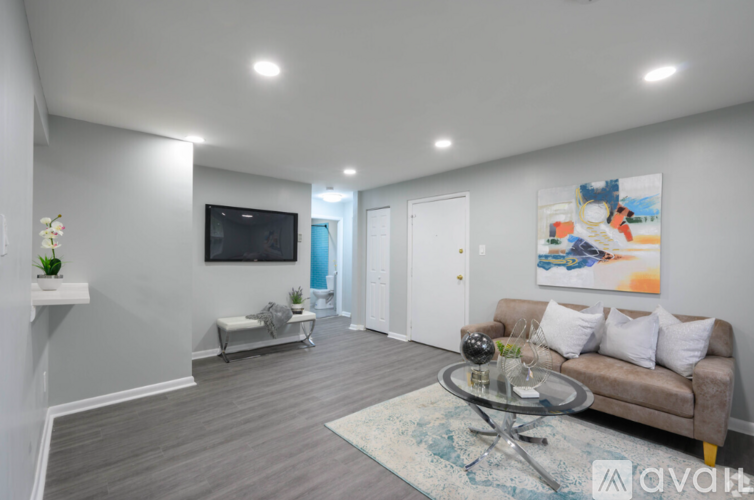 A living room with a couch, a television, and a painting on the wall.