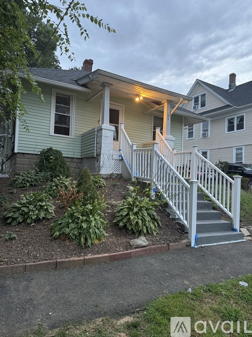 A house with a front yard and a staircase leading to the front door.