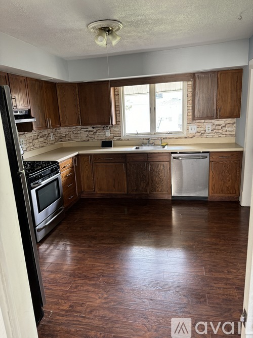 A kitchen with wooden cabinets and a white dishwasher.