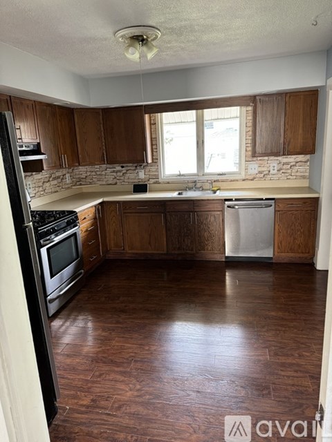 A kitchen with wooden cabinets and a white dishwasher.
