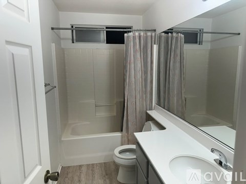 A bathroom with a toilet, sink, and bathtub.