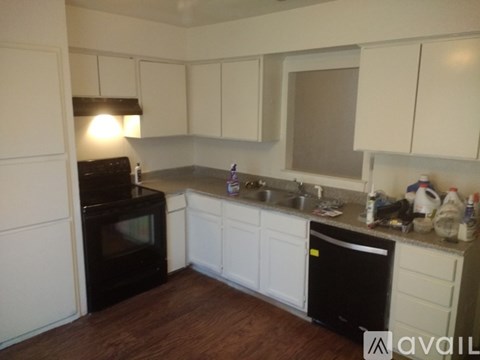 A kitchen with white cabinets and a black oven.