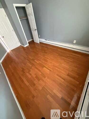 A room with wooden flooring and a white door.