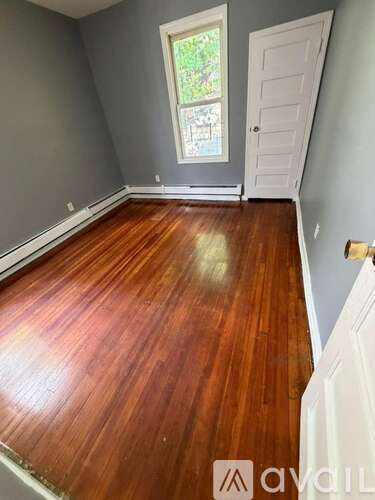 A room with wooden flooring and a white door.