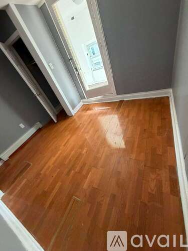 A room with wooden flooring and a window.