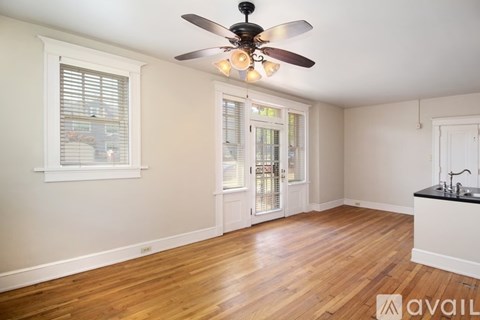A room with a ceiling fan and wooden floors.