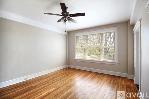 A room with a ceiling fan and wooden flooring.