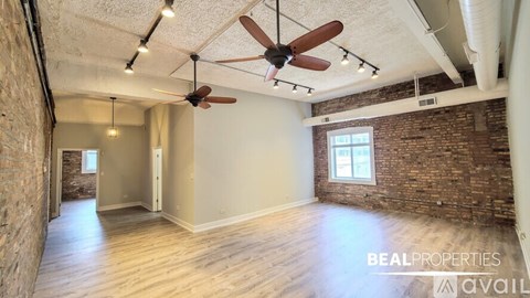 A room with a ceiling fan and wooden floors is available for rent.