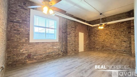 A room with a brick wall and a ceiling fan.