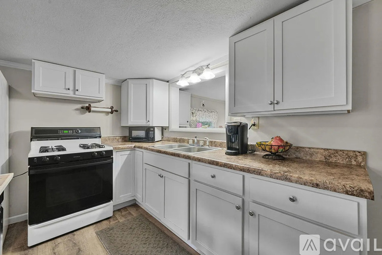 A kitchen with white cabinets and a black stove top.