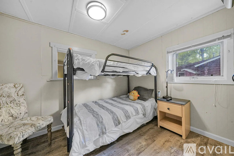 A bedroom with a bunk bed and a chair.