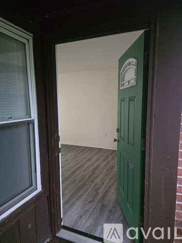 A green door is in a white room.