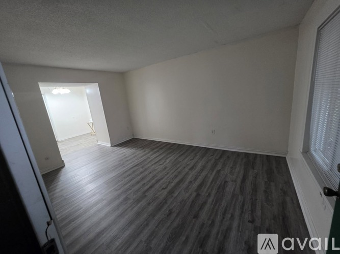 A room with wooden flooring and a window.