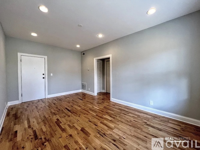 A room with wooden flooring and two doors.