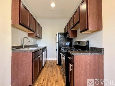 A kitchen with wooden cabinets and black appliances.