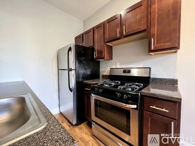 A kitchen with a black refrigerator, stove, and oven.