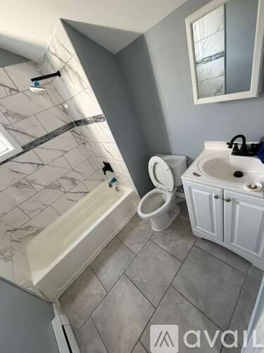 A bathroom with a toilet, sink, and bathtub.