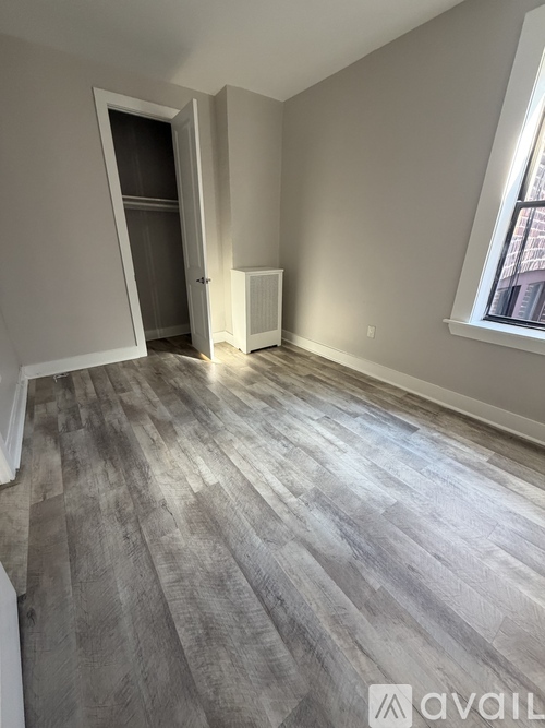 A room with a grey floor and a window on the right side.