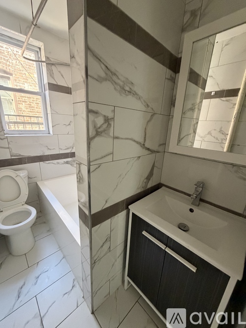 A bathroom with a toilet, sink, and mirror.