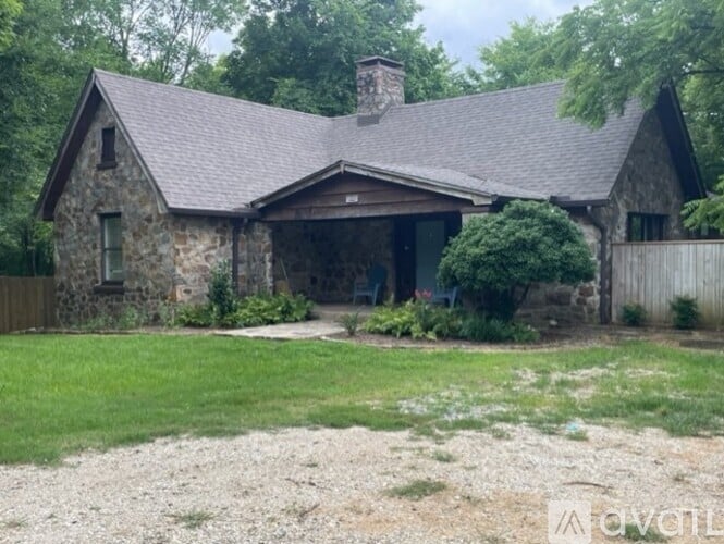A house with a stone exterior and a grey roof.