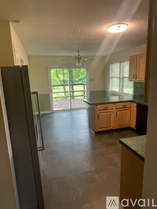 A kitchen with wooden cabinets and a black refrigerator.