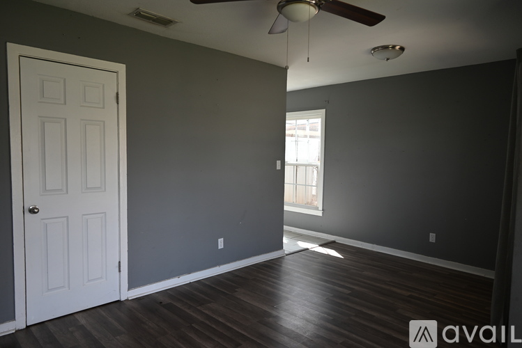 A room with a white door and a ceiling fan.
