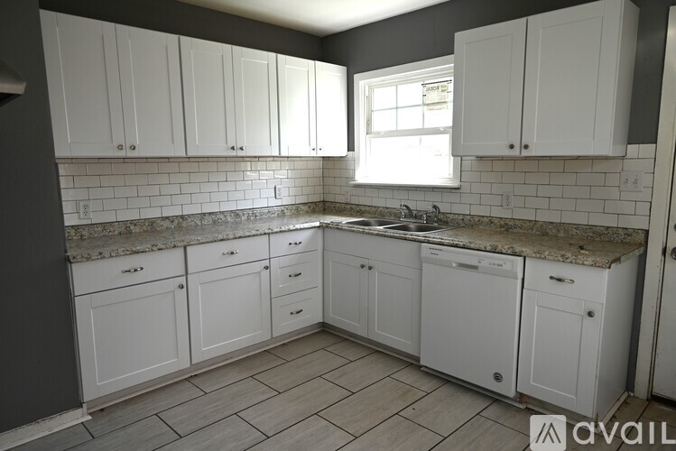 A kitchen with white cabinets and a granite countertop.
