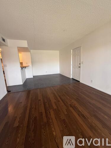 A room with wooden flooring and white walls.