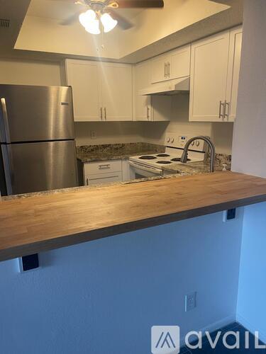 A kitchen with a stainless steel refrigerator and a wooden countertop.
