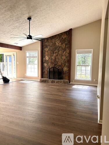 A room with a fireplace and a fan on the ceiling.