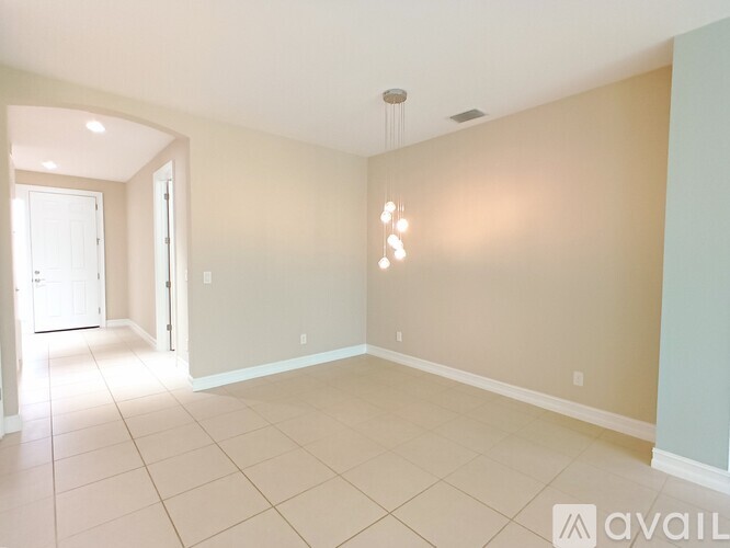 A spacious room with beige walls and a tiled floor.