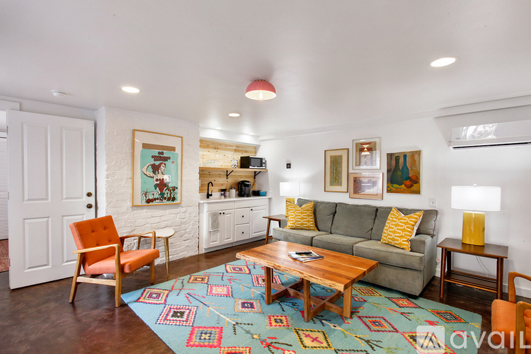 A living room with a couch, chair, and rug.